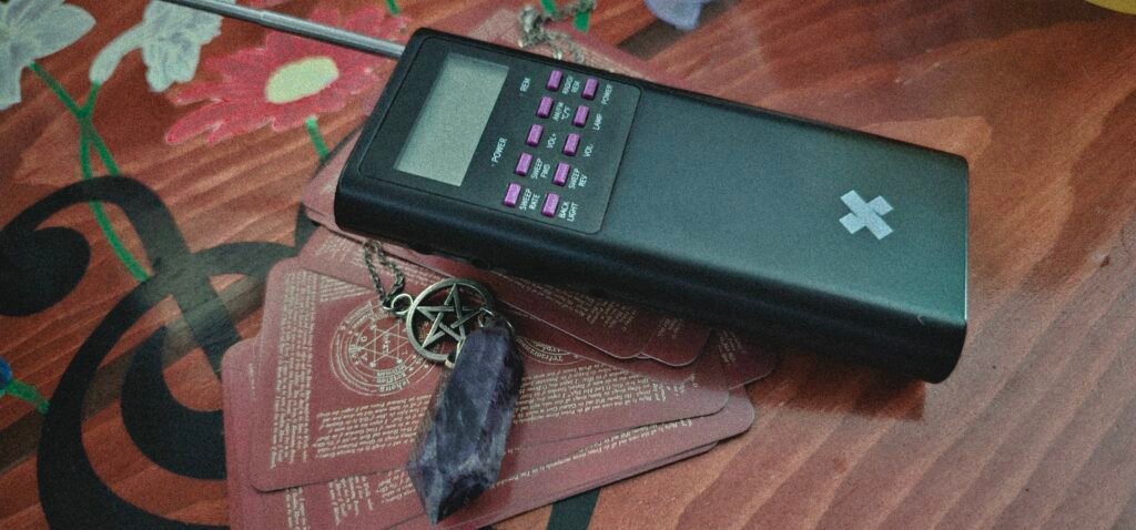 Spirit box and amethyst pendulum on tarot cards